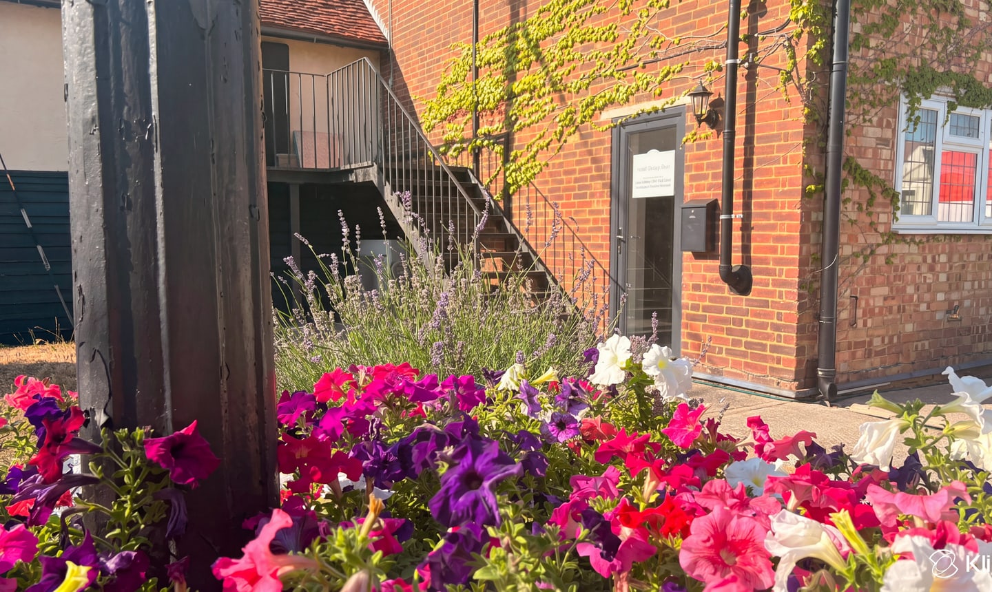 Essex Therapy Barn courtyard with flowers in front of the brick barn
